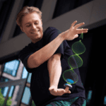 Young man performing with a glow-in-the-dark yo-yo at YoYoFactory Europe event.