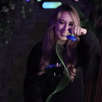 Young woman performing a yo-yo trick with a YoYoFactory yo-yo in a vibrant, colorful setting.