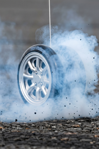 High-speed yo-yo tire explosion with smoke and debris.