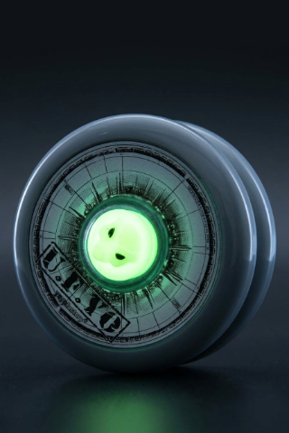 Close-up of a high-tech yo-yo with glowing green center and sleek design.